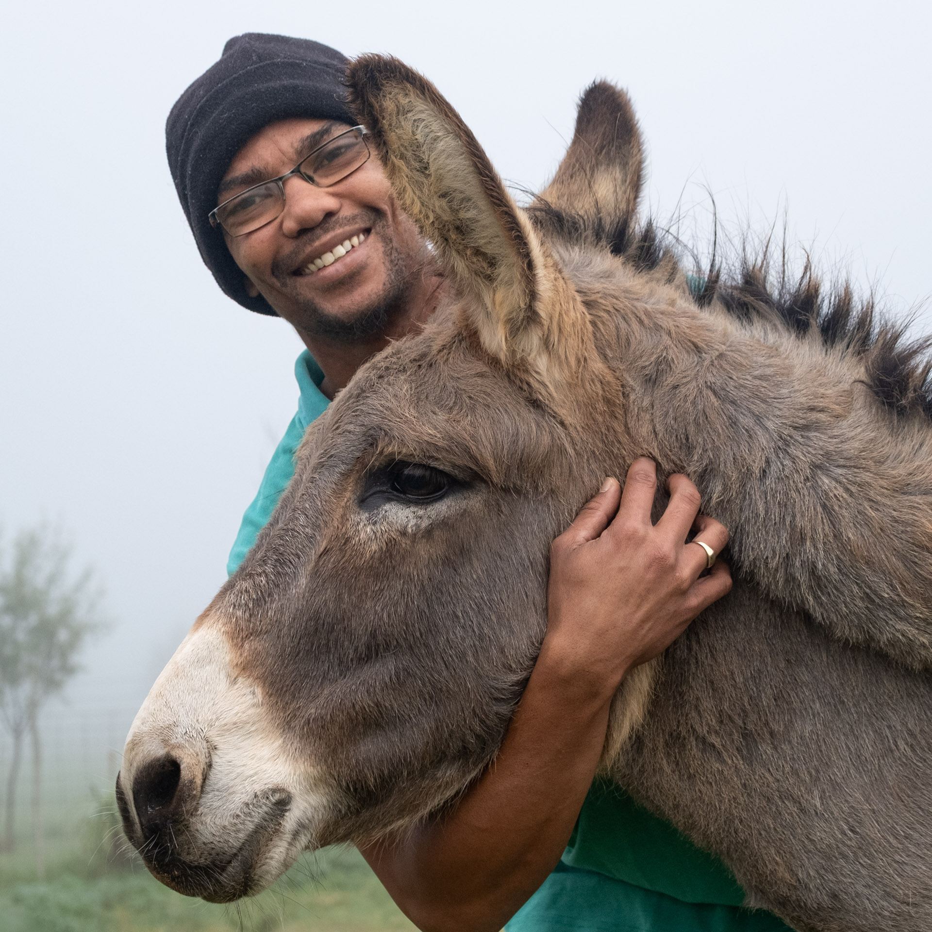 Smiling carer hugging a donkey at Eseltjiesrus Donkey Sanctuary, McGregor